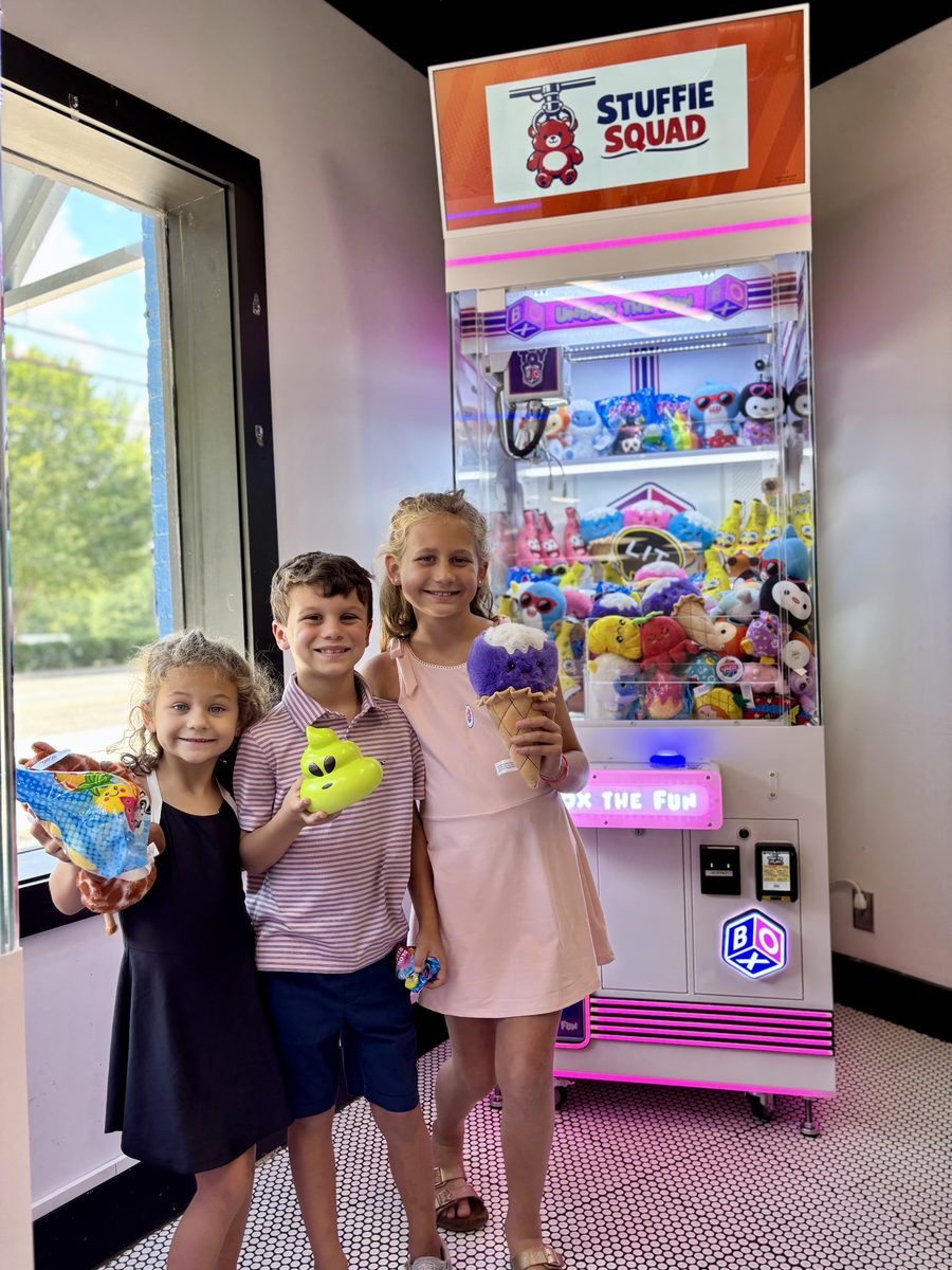 Three kids holding stuffies they won at Neighbors West Homewood